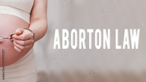The inscription abortion law and chained hands of a pregnant woman, home living room