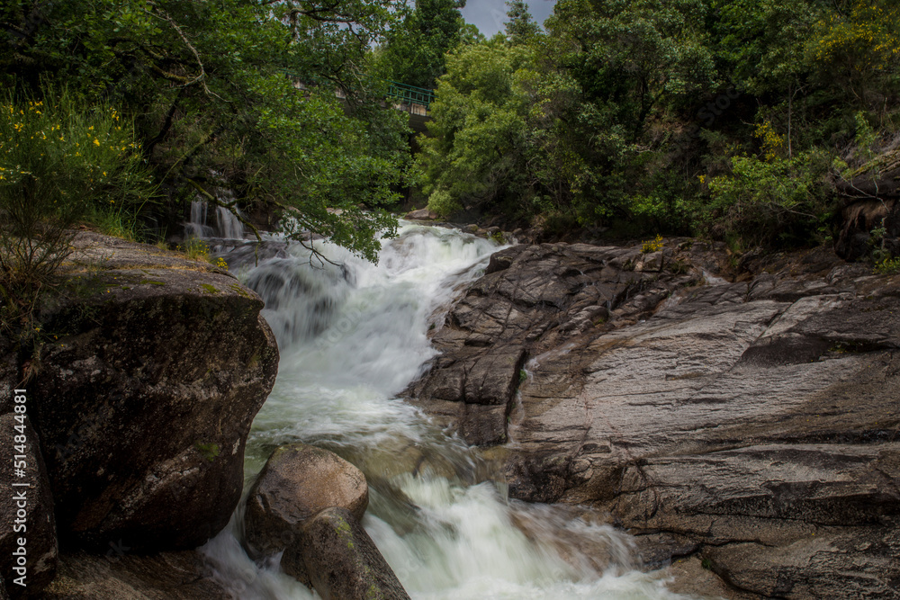 Naklejka premium Landscape detail of waterfall of running water over large rocks.