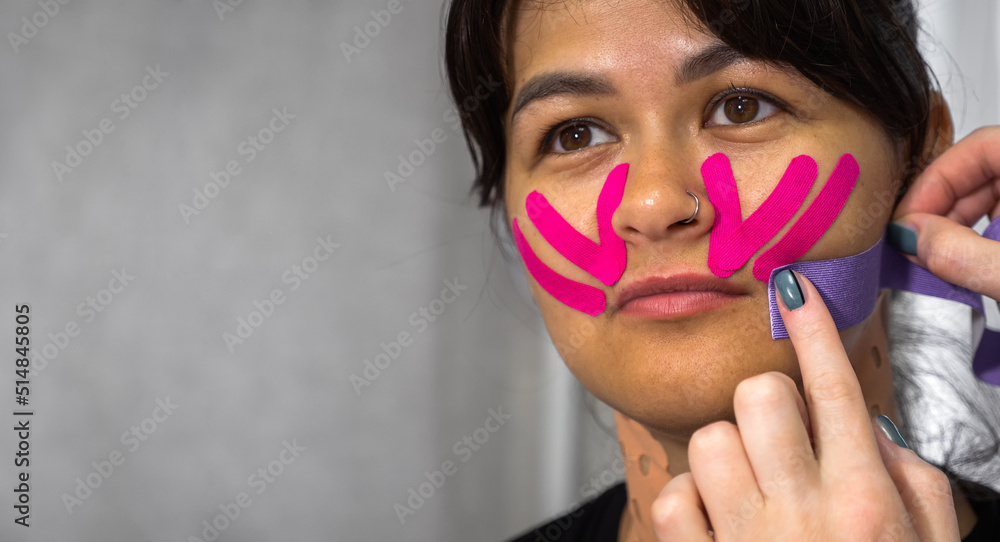 Physiotherapy of Face aesthetic taping. Portrait of woman with pasted konesiotape for rejuvenation and face tightening without surgery. Anti-wrinkle cosmetic tape. banner with copy space