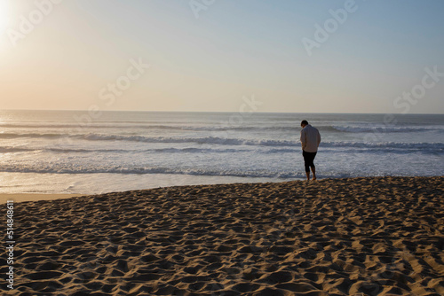 Boy standing on beach during sunset in France