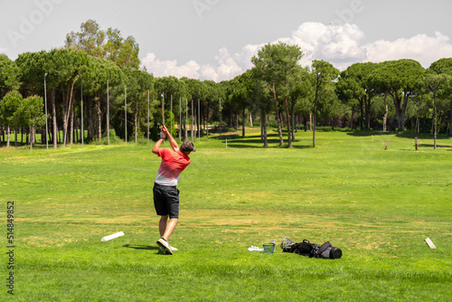 Golf player exercising on golf driving range before golf tournament