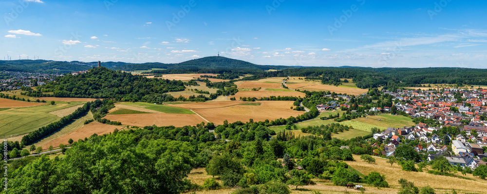 Naklejka premium Übersicht über die mittelhessische Gemeinde Krofdorf-Gleiberg in einer Panoramaaufnahme bei sonnigem Sommerwetter mit Horizont, wolkenlosem Himmel, der Ruine der Burg Vetzberg mit ihrem Bergfried und 