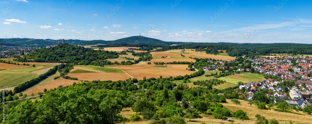 Übersicht über die mittelhessische Gemeinde Krofdorf-Gleiberg in einer Panoramaaufnahme bei sonnigem Sommerwetter mit Horizont, wolkenlosem Himmel, der Ruine der Burg Vetzberg mit ihrem Bergfried und 