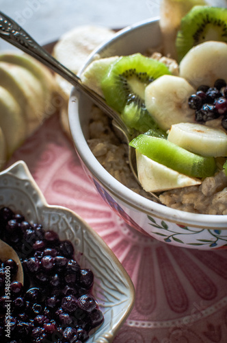 oatmeal with fruits, healthy breakfast on pink plate, blueberries,