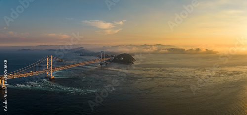 Panoramic aerial view of Naruto Bridge and whirlpools at sunset