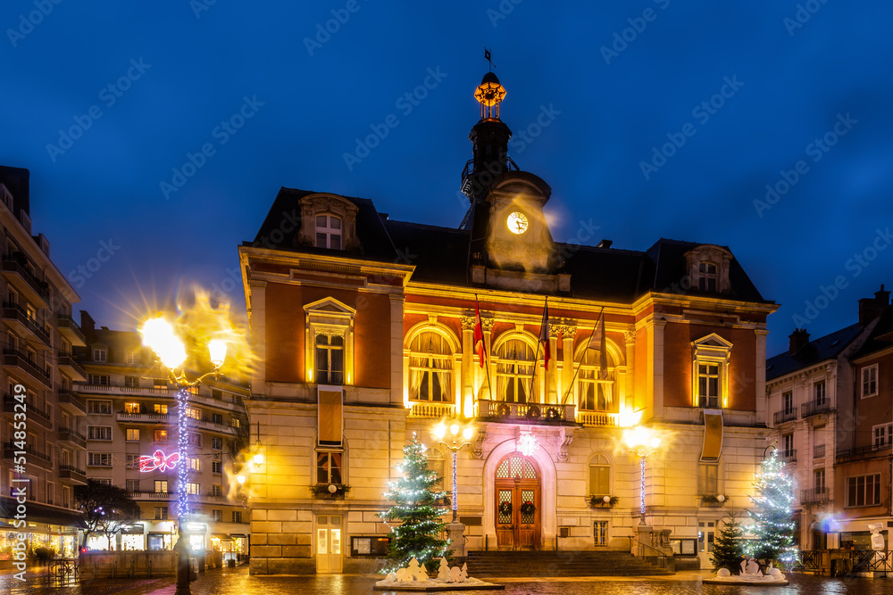 Scenic night view of Chambery town hall in central square during winter Christmas season with bright lighting and traditional decorations, France