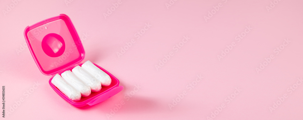 Tampons in pink box. Feminine hygiene products on pastel background. Menstruation and womens health concept. Banner format. Tampons in pink box. Feminine hygiene products on pastel background. Menstruation and womens health concept. Banner format.