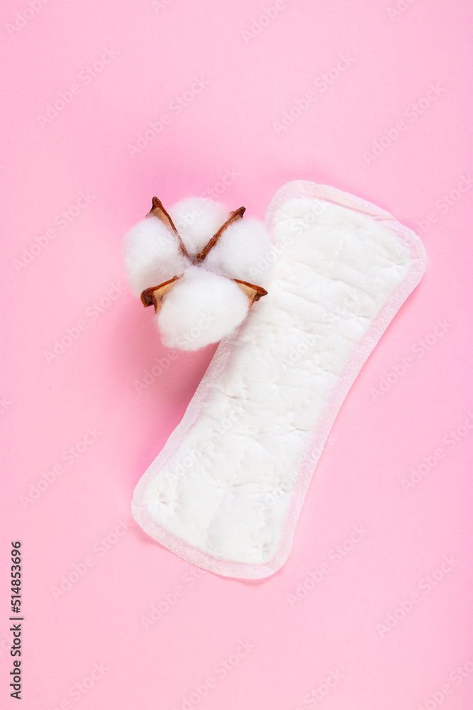 Sanitary pad and cotton flower on pink background. Daily feminine hygiene product. Menstruation and womens health concept. Vertical photo. Sanitary pad and cotton flower on pink background. Daily feminine hygiene product. Menstruation and womens health concept. Vertical photo.