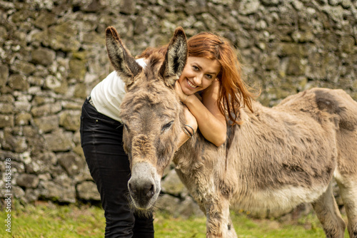 Girl with donkey, farm animals, having fun together, outdoors. © Ayla Harbich