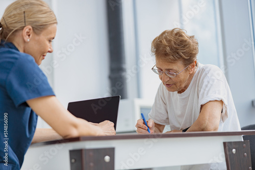 Female patient signing treatment agreement in doctor s office in clinic. High quality photo