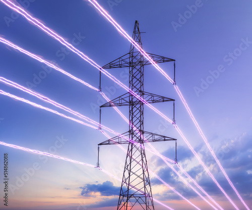Photo Electric transmission tower with glowing wires against the sunset sky
