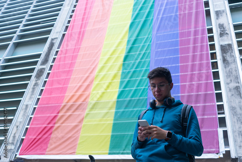 young man homosexual typing on his smartphone photo