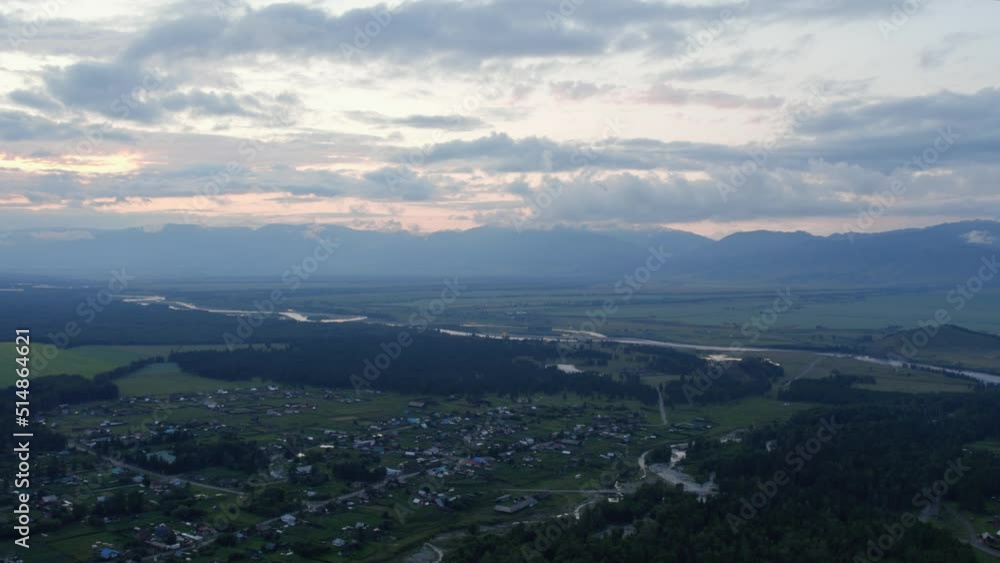 Aerial of valley in Altai and country houses under sunset sky, Siberia, Russia. Beautiful summer nature landscape at during sunset. Aerial view from a drone Aerial of valley in Altai and country houses under sunset sky, Siberia, Russia. Beautiful summer nature landscape at during sunset. Aerial view from a drone