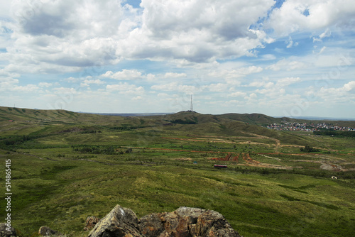 View of the city of Ust-Kamenogorsk (kazakhstan). Summer steppe. Green grass and blue sky. Hills. Cityscape photo