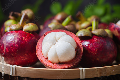 Fresh Mangosteen fruit and half mangosteen on wooden table photo