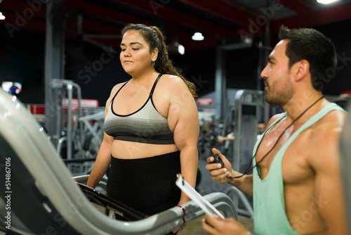 Personal fitness trainer helping a plus size woman