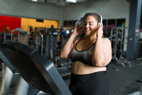 Cheerful fat woman exercising with music