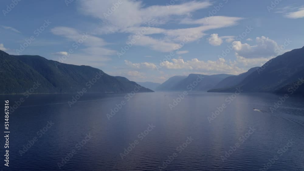 Coastline of lake Teletskoye between mountains and blue clear sky in Altai, Siberia, Russia. Beautiful summer nature landscape at during daytime. Aerial view from a drone Coastline of lake Teletskoye between mountains and blue clear sky in Altai, Siberia, Russia. Beautiful summer nature landscape at during daytime. Aerial view from a drone