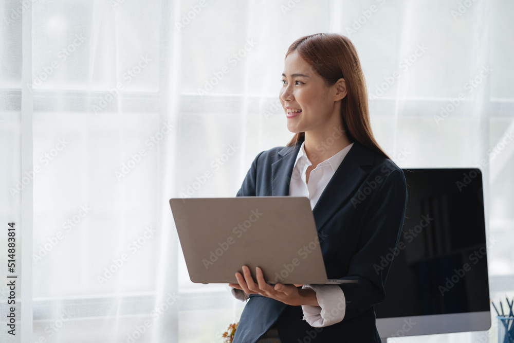 Young business women working and typing on laptop with happy and smile face on office spec. Young business women working and typing on laptop with happy and smile face on office spec.