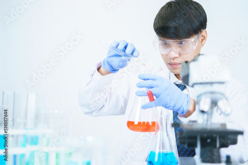 Asian scientists are seriously studying the chemical composition in the laboratory. Specializing in Young Biotechnology Use advanced microscope equipment.