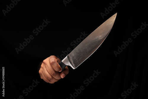 Asian male dark skinned single hand fist finger on black background holding stainless steel knife