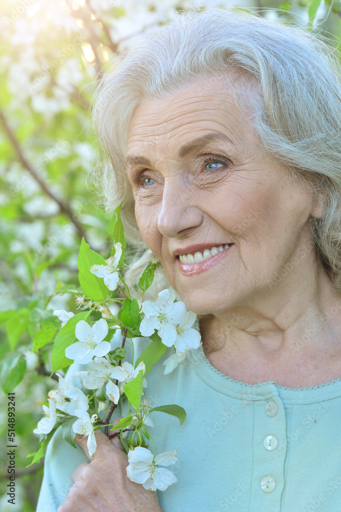Cute happy smiling senior woman posing in park outdoors Cute happy smiling senior woman posing in park outdoors