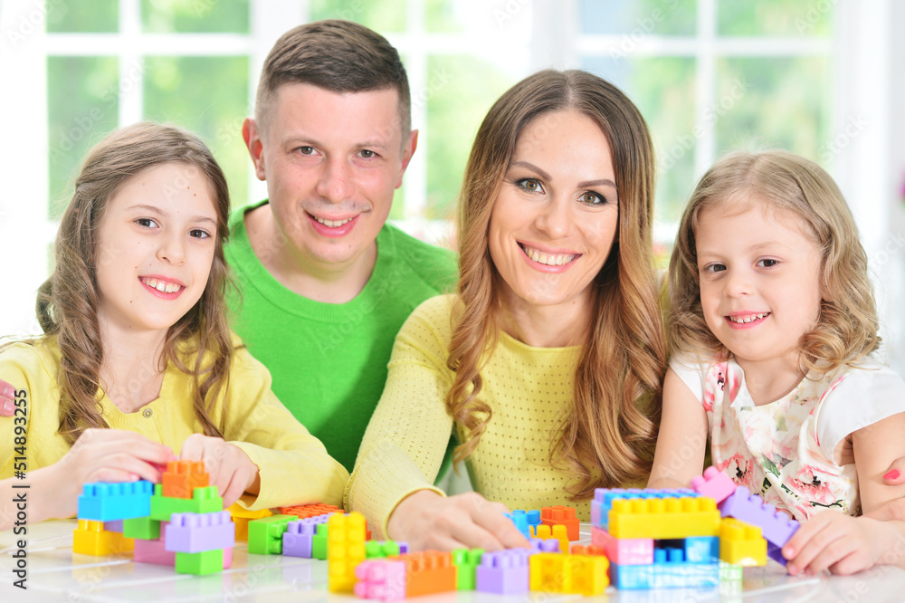 Girl with mother and father playing with colorful plastic blocks Girl with mother and father playing with colorful plastic blocks