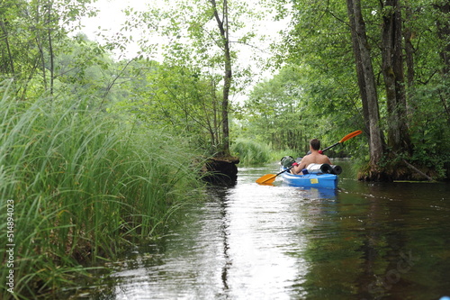 Kayaking in a kayak or canoe in the river in Poland in summer with lush green nature around © piotrmilewski