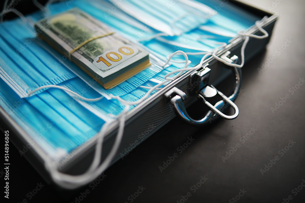 A metal suitcase with a batch of disposable masks. New reality, new values. Money masks. A metal suitcase with a batch of disposable masks. New reality, new values. Money masks.