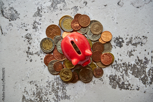czerwona świnka skarbonka i różne monety 