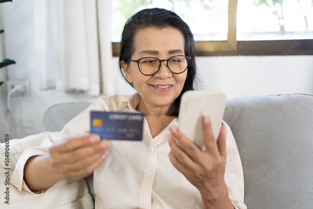 Senior woman with smart phone for online shopping.  Hand holding mobile phone with Payment on credit card online shopping electronic wallet Payment Shopping by phone and connected card concept