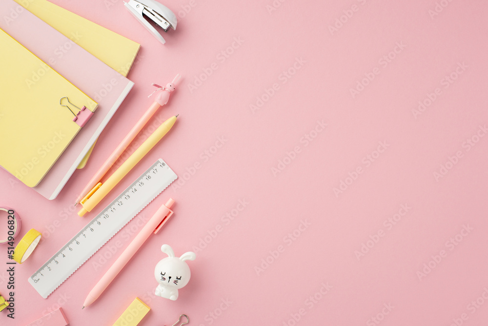 Back to school concept. Top view photo of school accessories diaries pens ruler mini stapler binder clips adhesive tape erasers and bunny shaped sharpener on isolated pink background with empty space Back to school concept. Top view photo of school accessories diaries pens ruler mini stapler binder clips adhesive tape erasers and bunny shaped sharpener on isolated pink background with empty space