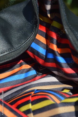 Detail of the inside of a handbag with a colorful striped fabric. 