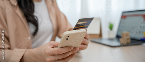woman uses a credit card to pay for goods after shopping online through a socially marketed merchant s website. The buyer pays for water  electricity and telephone bills via computer by debit card.