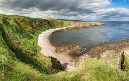 Cliff  in a bay with blue sky and white cloudsnear  in Dunnottar Castle, Scotland - UK photo