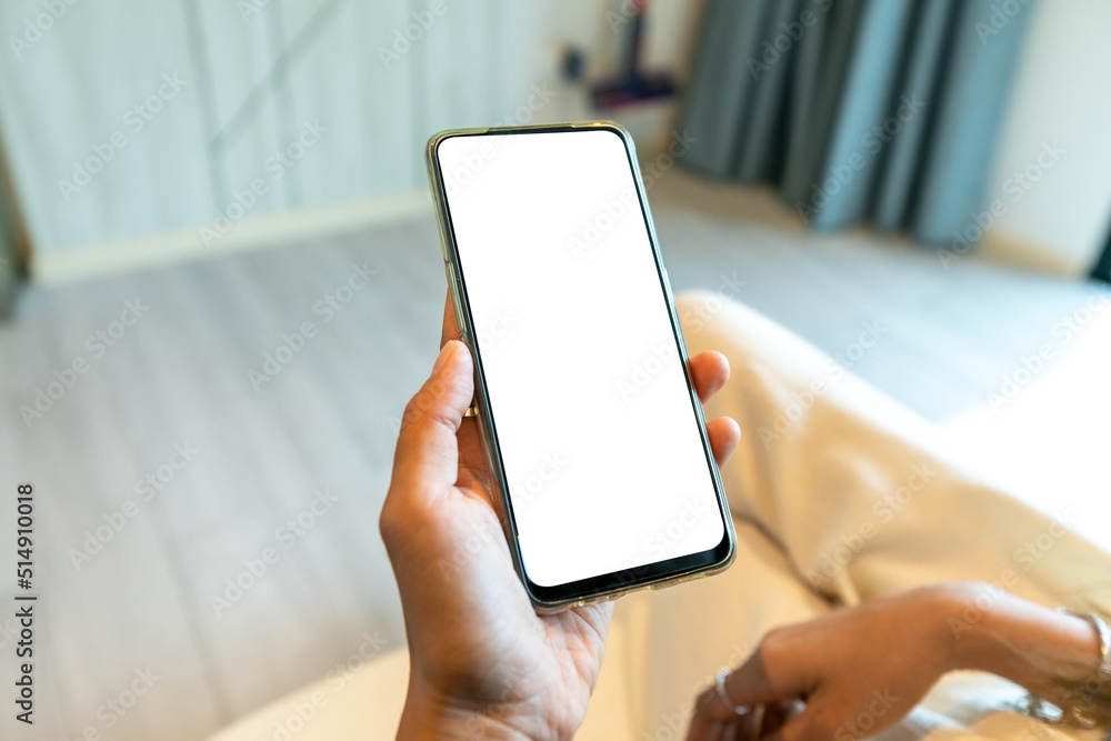 Female hand holding smartphone with blank screen and stylish frameless design, isolated on white background. Female hand holding smartphone with blank screen and stylish frameless design, isolated on white background.