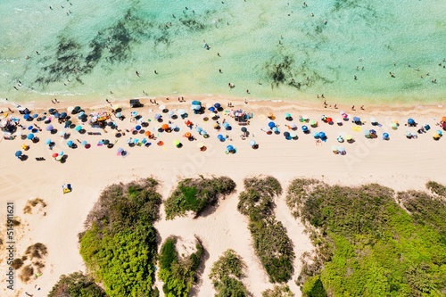 Punta Prosciutto (Porto Cesareo, Salento, Puglia, Italia) vista dal drone in estate con dune e ombrelloni colorati