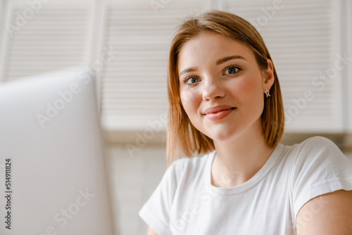 Smiling young woman studying with laptop computer
