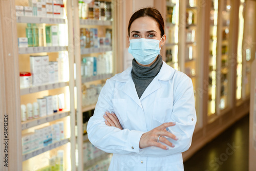 White apothecary wearing lab coat and face mask working in pharmacy