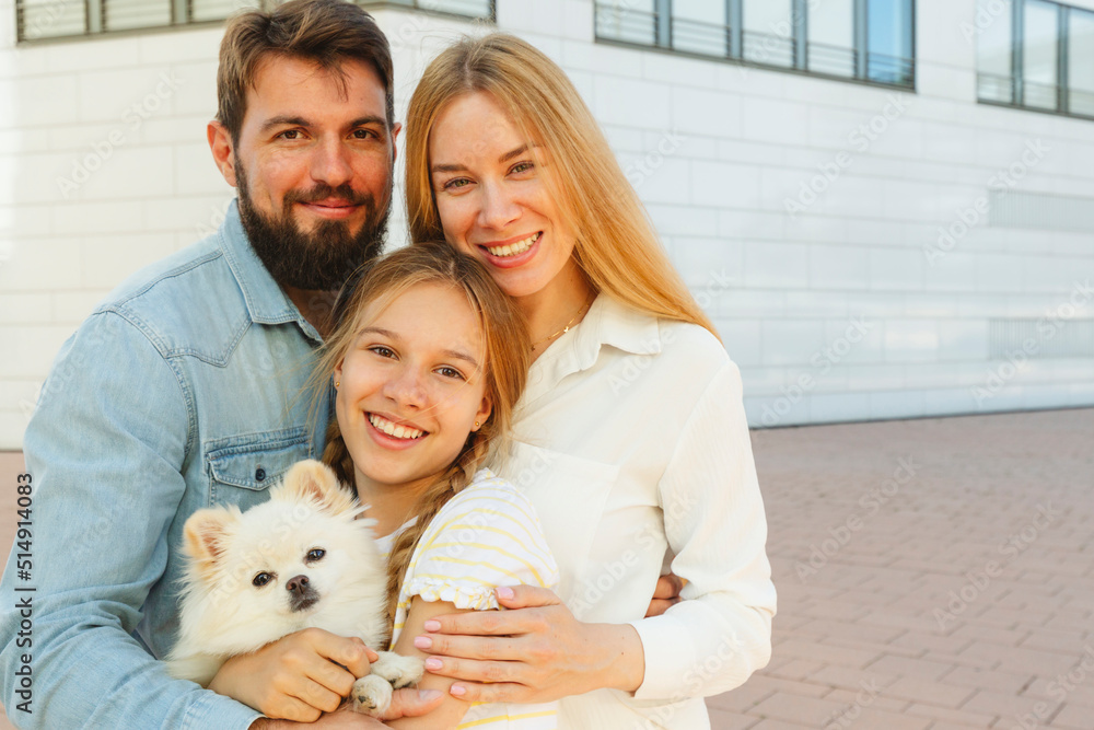 Happy family with dog standing in front of building Happy family with dog standing in front of building