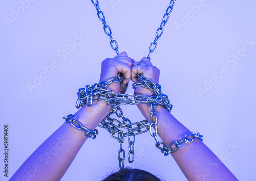 Hands of woman tied with chain photo