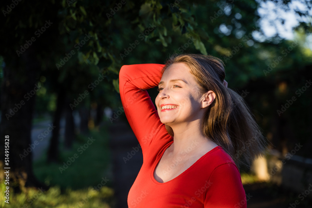 Happy woman with hand in hair enjoying sunlight Happy woman with hand in hair enjoying sunlight