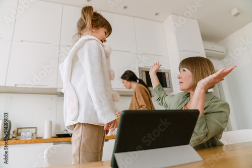 White girl using tablet computer while spending time with her family