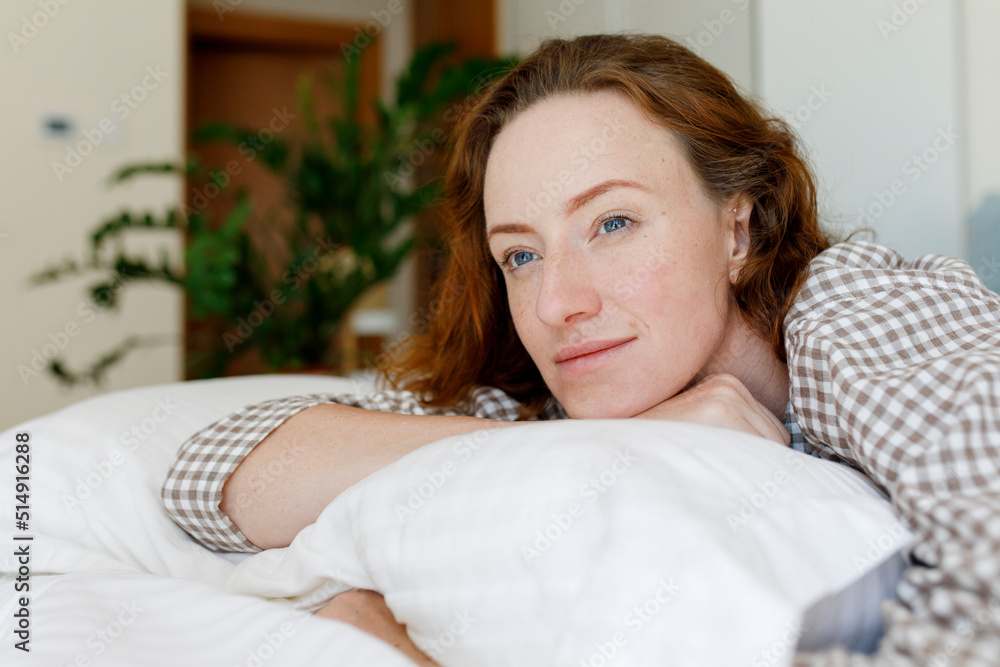 Thoughtful woman lying on bed with pillow in bedroom Thoughtful woman lying on bed with pillow in bedroom