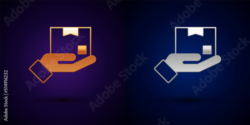 Gold and silver Delivery hand with cardboard boxes icon isolated on black background. Door to door delivery by courier. Vector