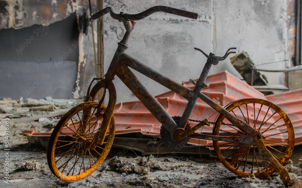 Irpin, Ukraine - May 22, 2022: a burned children's bicycle in a house destroyed by Russian troops after the occupation of the city