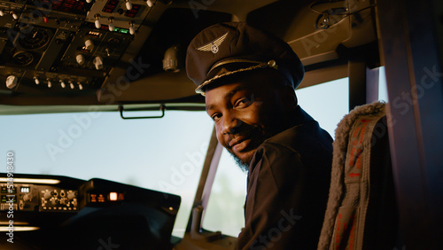 Foto Portrait of male copilot pressing power switch buttons to takeoff and fly airplane, using control panel command in cockpit