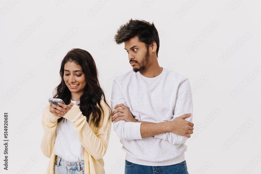 East asian young man and woman smiling and using cellphone together East asian young man and woman smiling and using cellphone together