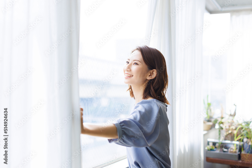 カーテンを開ける女性 カーテンを開ける女性