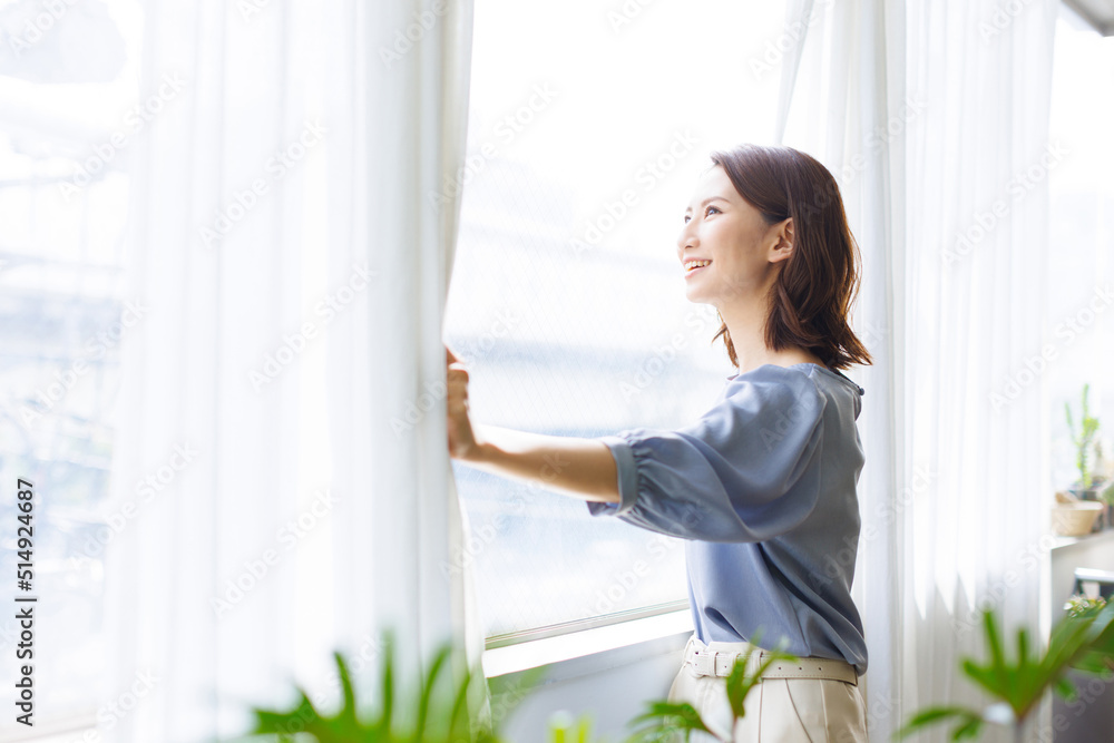 カーテンを開ける女性 カーテンを開ける女性